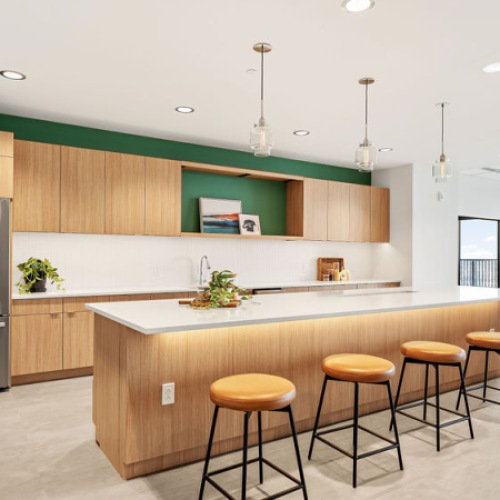 Communal kitchen area with stainless steel appliances and a large island with barstools