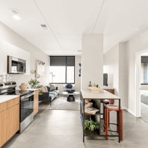 Kitchen and living area with stainless steel appliances and seating options