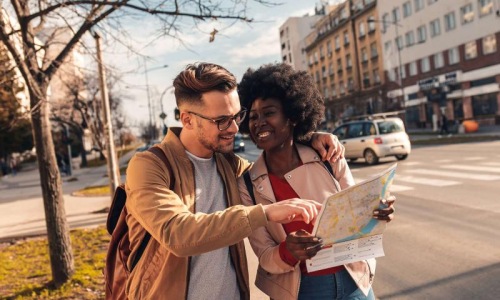 a man and woman looking at a map in the city