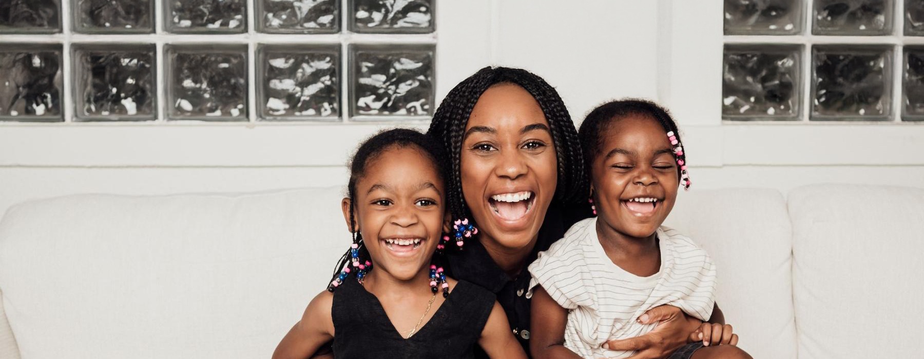 a woman sitting on a couch with two kids